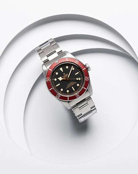 Une montre TUDOR pour hommes sur fond blanc.